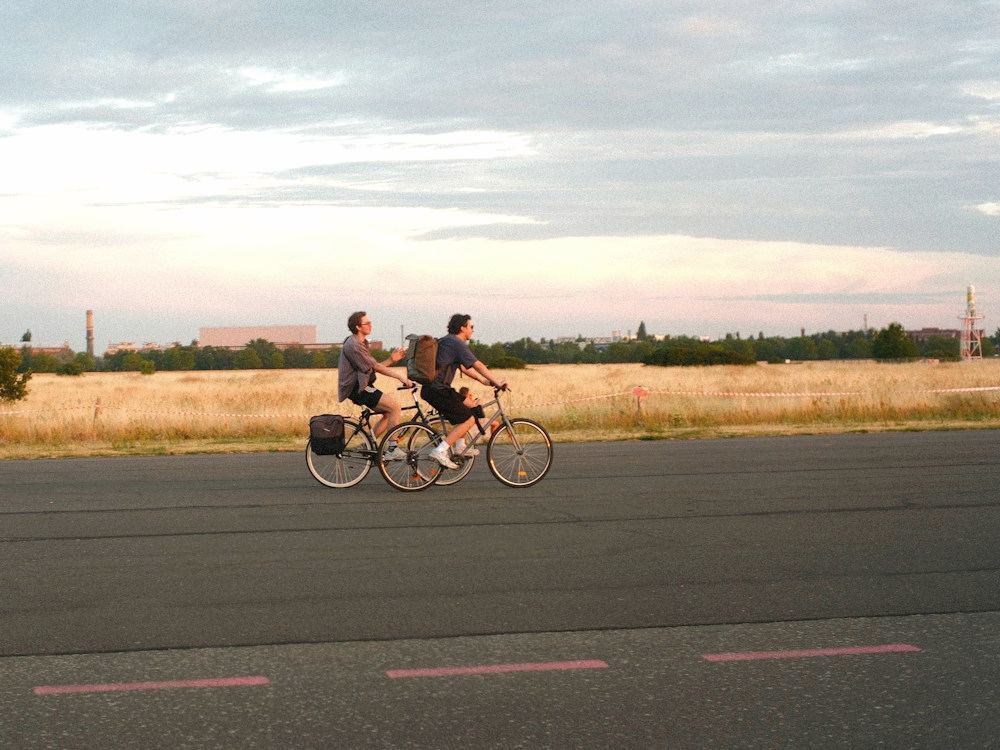 Two people cycling together at sunset