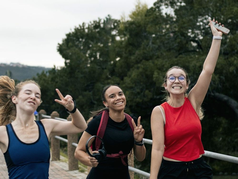 Three friends laughing together after a run
